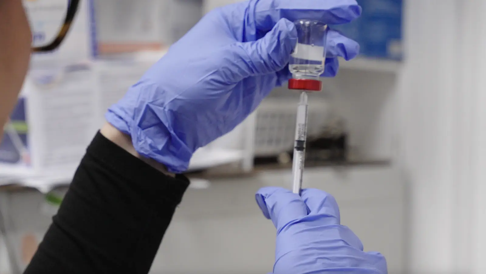 A pharmacist drawing a vaccine dose from a vial