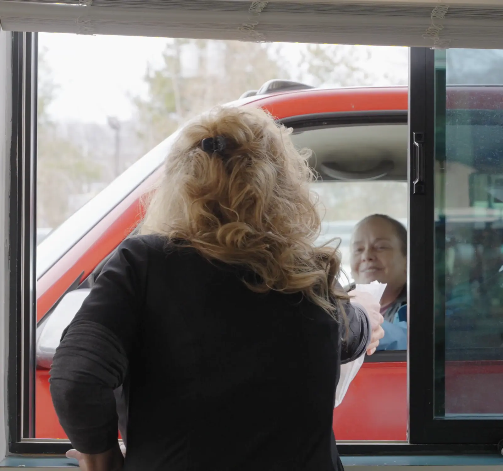 Stultz Pharmacy staff handing a prescription through the drive-thru window